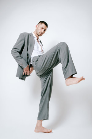 Fashion man model in gray suit, barefoot, shoot in studioの写真素材