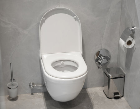 White clean toilet bowl in restroom with trash can and toilet paper and brushの写真素材