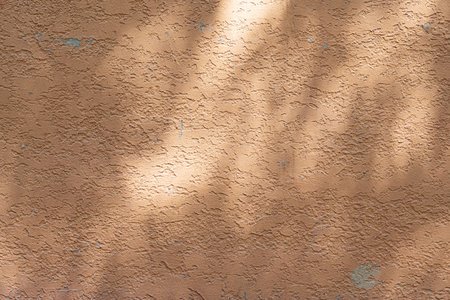 Wall with texture and shadows. Orange, brown concrete backgroundの写真素材