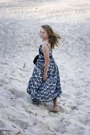 Pretty smiling and happy teenager walking on the beach.の写真素材