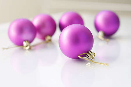 A close-up of a purple colored Christmas bauble decorations on a glass table.の写真素材