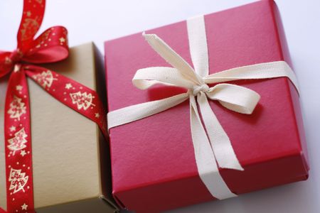 A close-up of a number of Christmas gifts on a light surface and completed with ribbons and bows.の写真素材