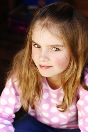 A close-up portrait of a pretty and happy long haired young girl posing for the camera.の写真素材