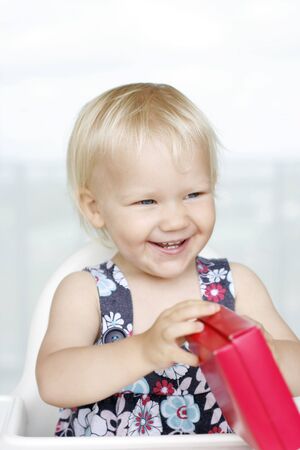 A happy little girl gleefully opening Christmas gifts.の写真素材