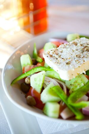 Delicious and fresh greek salad on an outdoor restaurant tableの写真素材