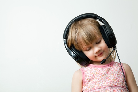 Little girl with headphones listening to musicの写真素材