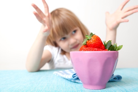 Little girl with a bowl of delicious strawberriesの写真素材