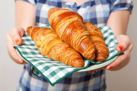 Young woman holding a plate of croissantsの写真素材
