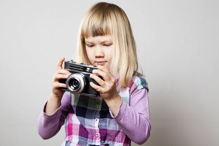 Little girl with a vintage camera. Studio shot.の写真素材