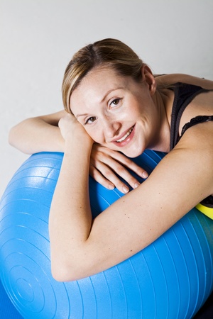 Pregnant woman relaxing while leaning against a fitness ball on a matの写真素材