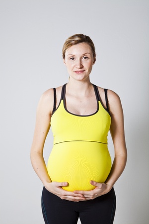 Beautiful young pregnant woman holding her tummyの写真素材