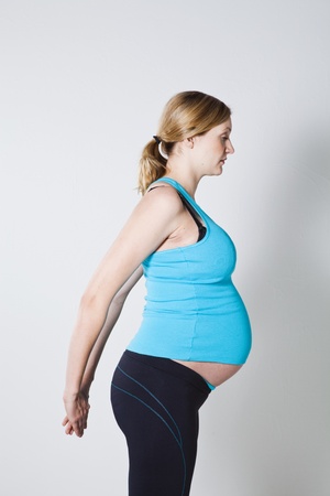 Pregnant woman performing a stretching exercise for the chest musclesの写真素材