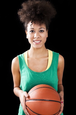 Athletic woman with a basketball. Studio shot with black backgroundの写真素材