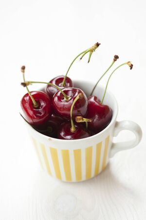 Close-up of fresh delicious and ripe cherries in a cupの写真素材