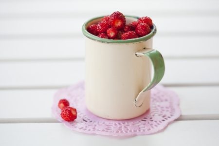 Close-up of a cup full of ripe, delicious wild strawberriesの写真素材