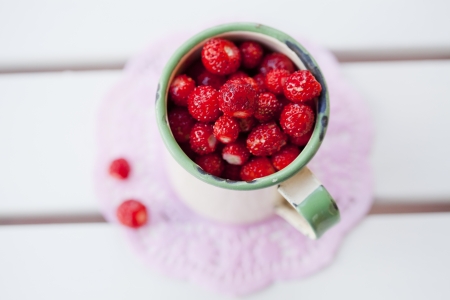 Close-up of a cup full of ripe, delicious wild strawberries