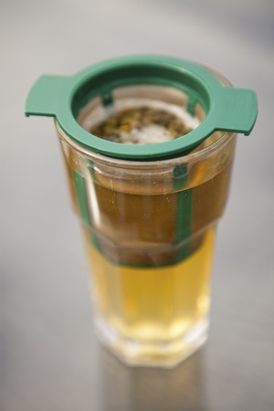 Close-up of a glass of green tea brewing on a tableの写真素材