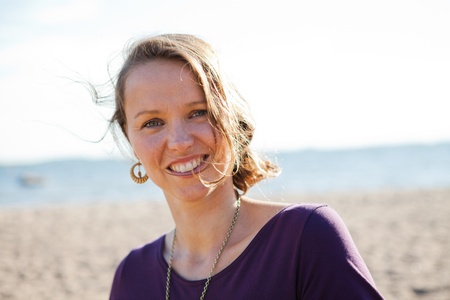 Portrait of a happy, smiling woman at the beach during summer.