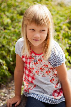 Young cute blond girl outdoors in summer.の写真素材