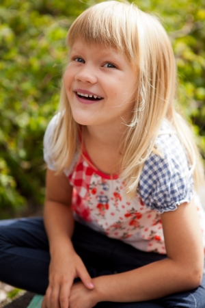 Young cute blond girl outdoors in summer.の写真素材