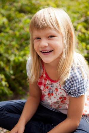 Young cute blond girl outdoors in summer.の写真素材