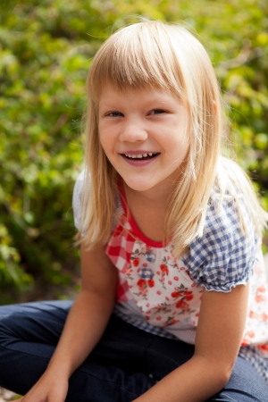 Young cute blond girl outdoors in summer.の写真素材