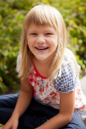 Young cute blond girl outdoors in summer.の写真素材