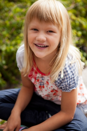 Young cute blond girl outdoors in summer.の写真素材