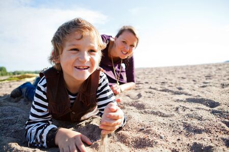 Mother and son relaxing and spending time together on the beach.の写真素材