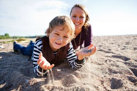 Mother and son relaxing and spending time together on the beach.の写真素材