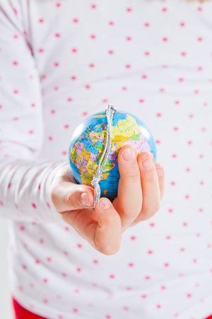 Studio portrait of young girl holding world globe in handの写真素材