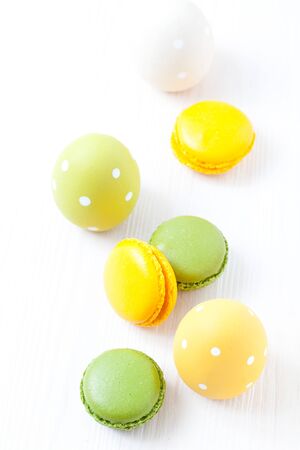 Close-up of colorful macaroons and Easter eggs on light backgroundの写真素材