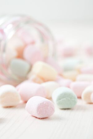 Colorful marshmallows in glass jar on light backgroundの写真素材