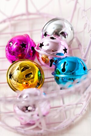 Closeup of colourful Christmas baubles in pink tray on light backgroundの写真素材