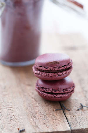 Closeup of two macaroons with glass jar of cocoa powder in backgroundの写真素材