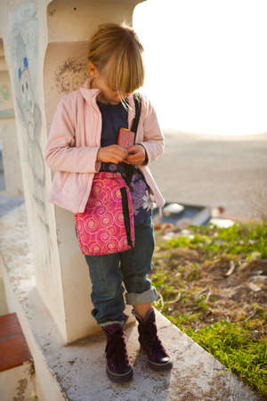 Thoughtful young girl standing in archway with beach in background in Nazare Portugalの写真素材