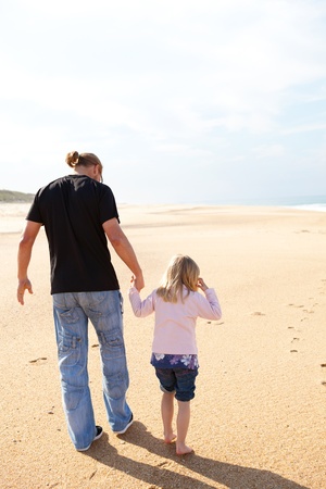 Father and daughter spending holiday time walking together at beach in Portugalの写真素材