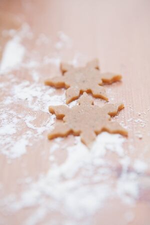 Closeup of two pieces of star shaped gingerbread doughの写真素材
