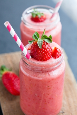 Closeup of strawberry fruit smoothies with strawberry pieces in glass with strawの写真素材