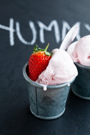 Closeup of strawberry ice cream and strawberry with chalk written word on dark backgroundの写真素材