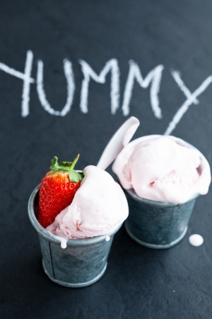 Closeup of strawberry ice cream and strawberry with chalk written word on dark backgroundの写真素材