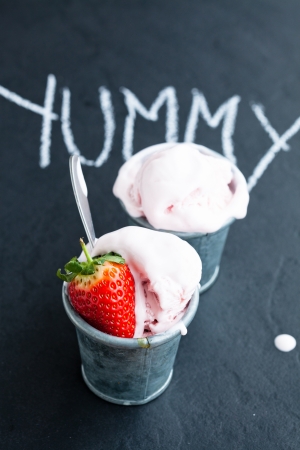 Closeup of strawberry ice cream and strawberry with chalk written word on dark backgroundの写真素材