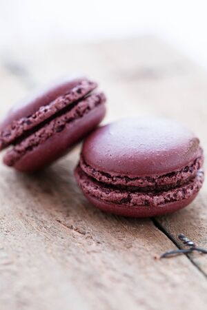 Closeup of two chocolate macaroons on wooden tableの写真素材