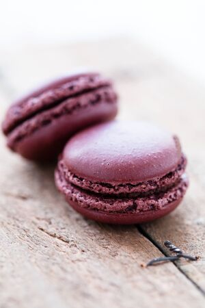 Closeup of two chocolate macaroons on wooden tableの写真素材
