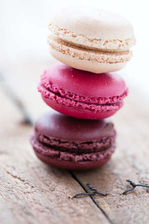 Closeup of stack of three different flavoured macaroons on wooden tableの写真素材