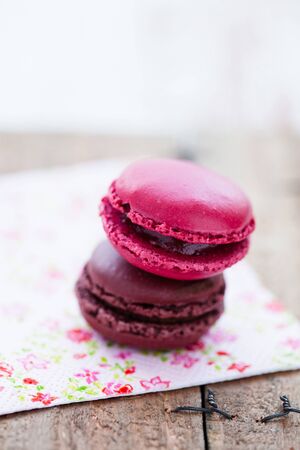 Closeup of two macaroons resting on serviette on wooden tableの写真素材