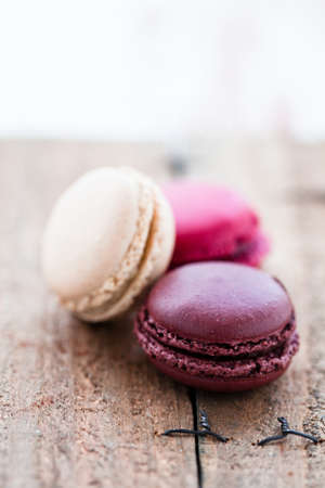 Closeup of three different flavoured macaroons on wooden tableの写真素材