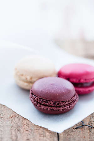 Closeup of three different flavoured macaroons on wooden tableの写真素材