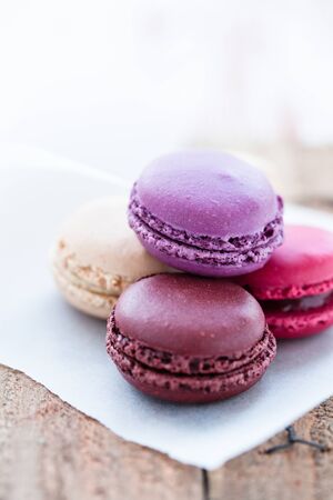 Closeup of four different flavoured macaroons on wooden tableの写真素材