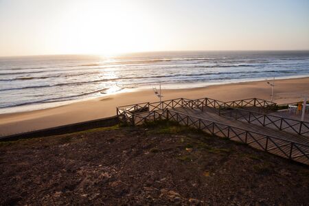 Sunset on Atlantic coast of Portugal at Praia da Areia Brancaの写真素材